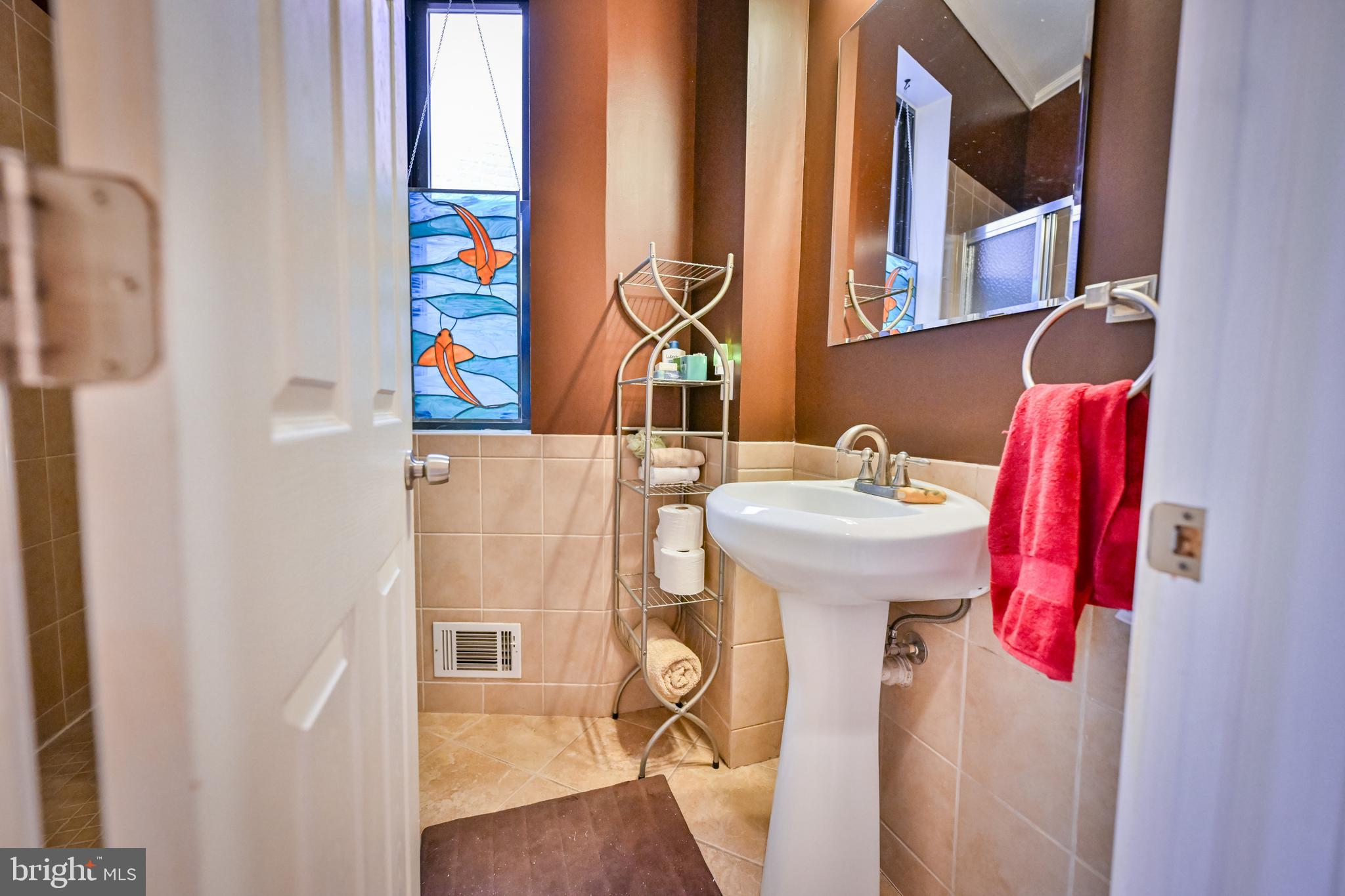 240 Wilson Street Baltimore, MD 21217 - Photo 35 of 63 a bathroom with a sink mirror and a window