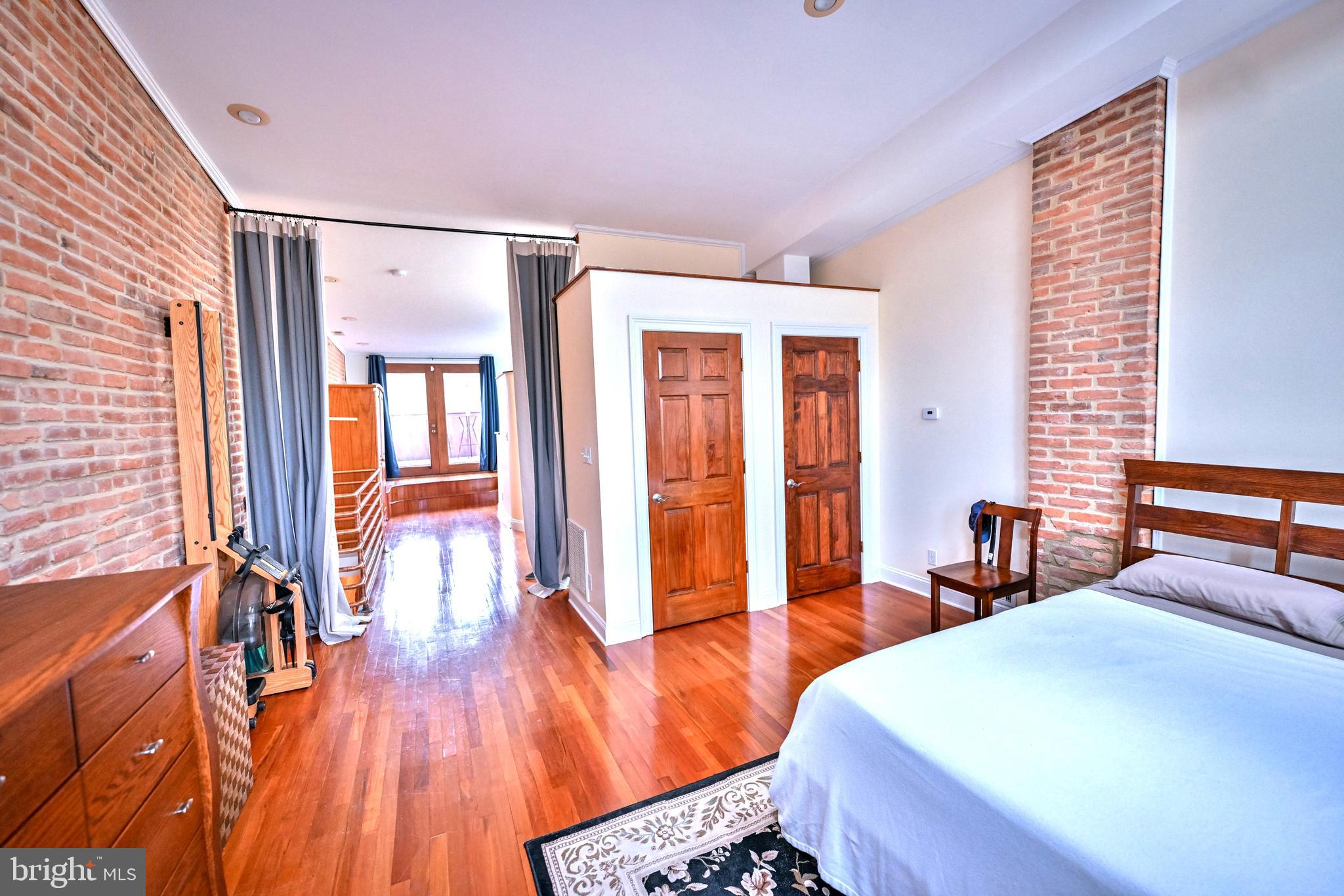 240 Wilson Street Baltimore, MD 21217 - Photo 42 of 63 a bedroom with a bed and wooden floor