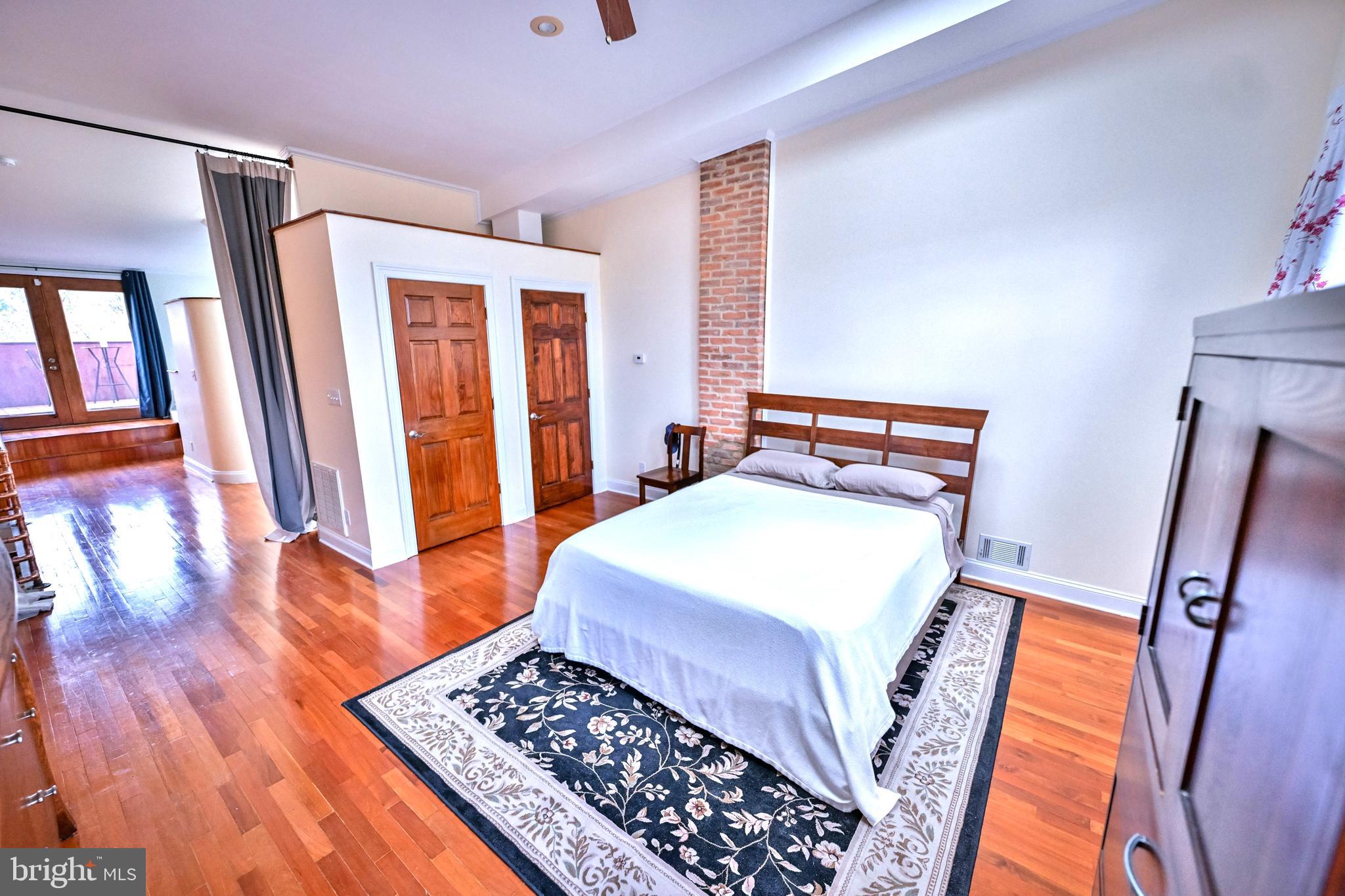 240 Wilson Street Baltimore, MD 21217 - Photo 43 of 63 a bedroom with a bed and wooden floor