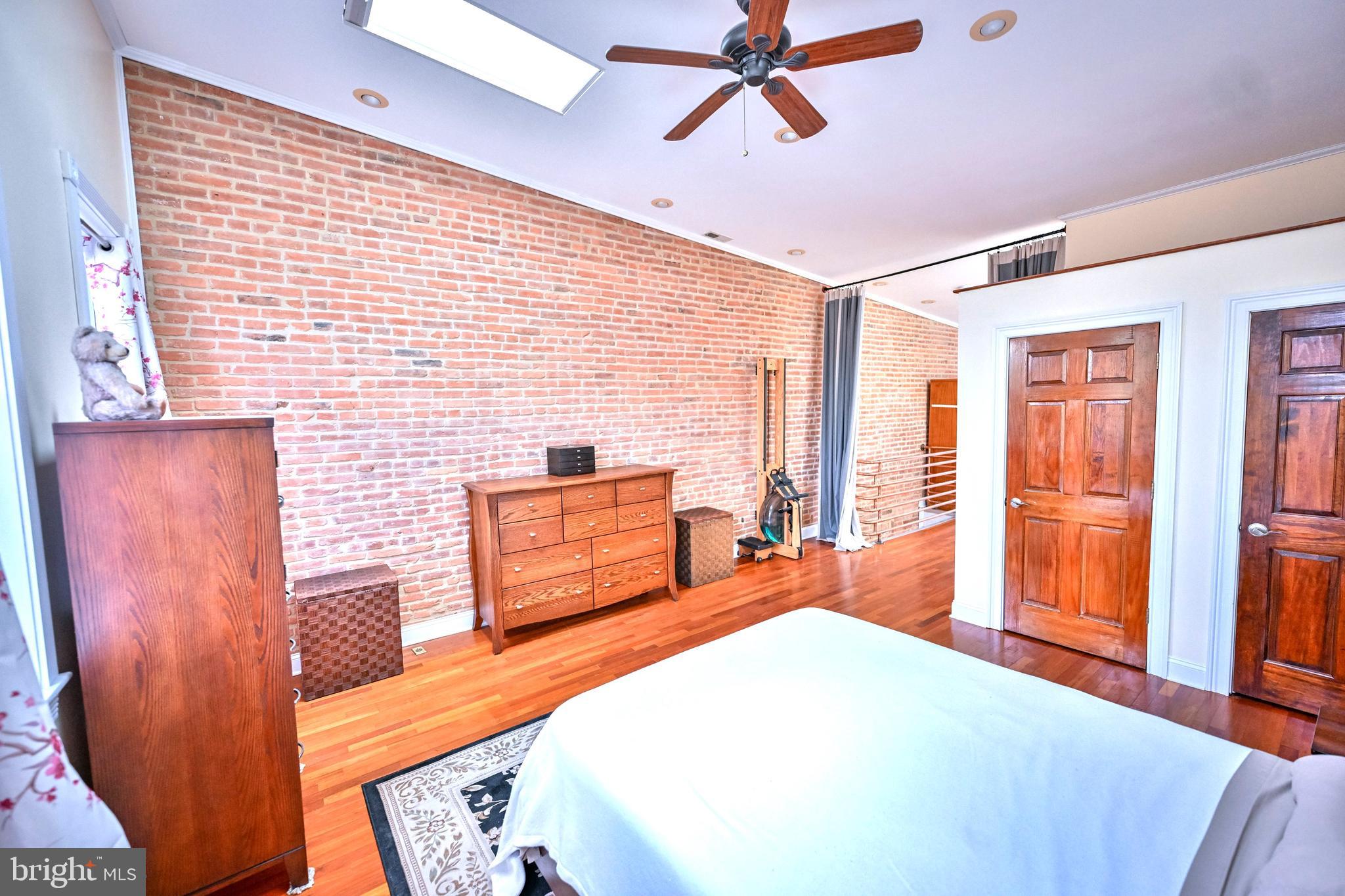 240 Wilson Street Baltimore, MD 21217 - Photo 44 of 63 a bedroom with a bed and wooden floor