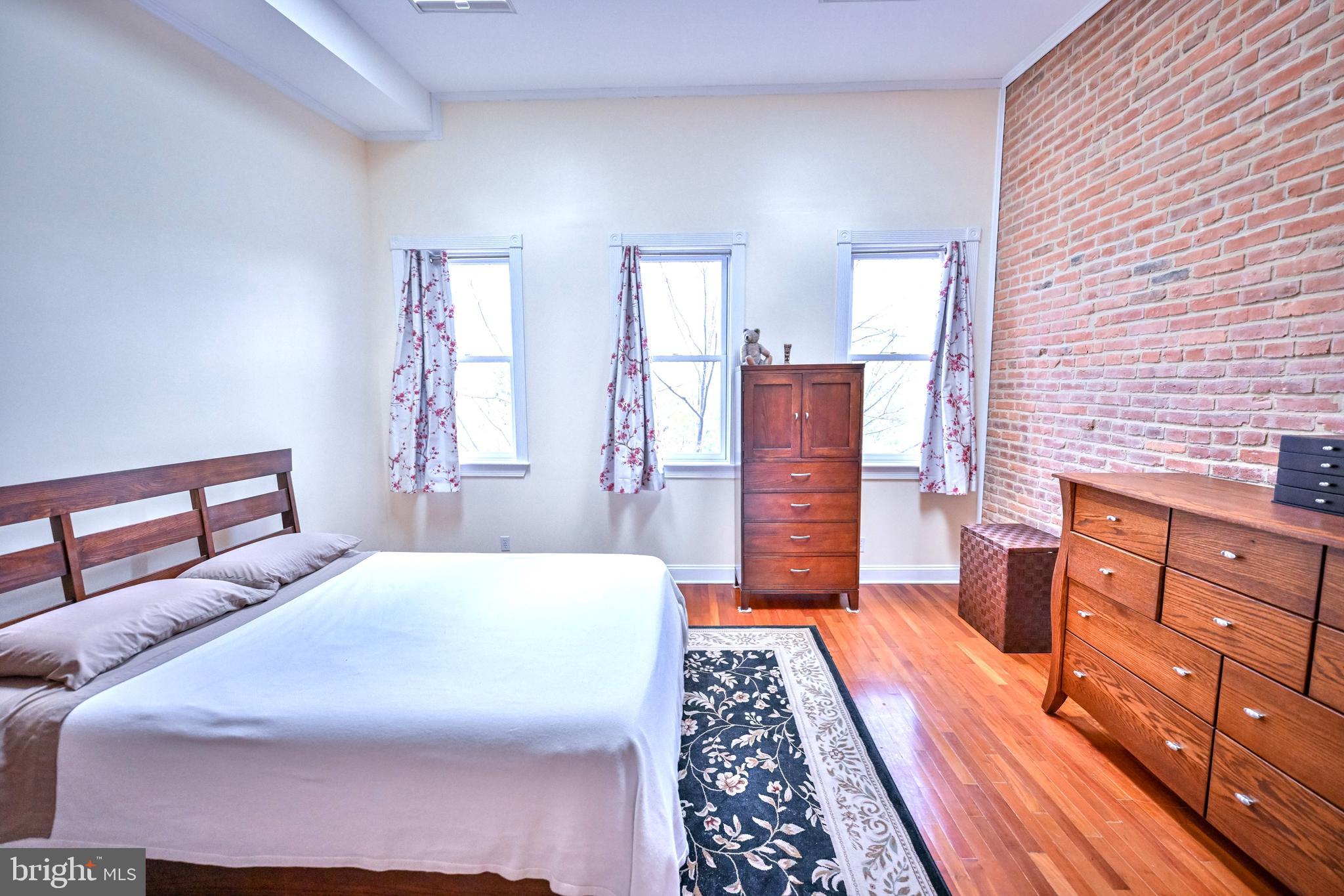 240 Wilson Street Baltimore, MD 21217 - Photo 48 of 63 a bedroom with a bed and wooden floor