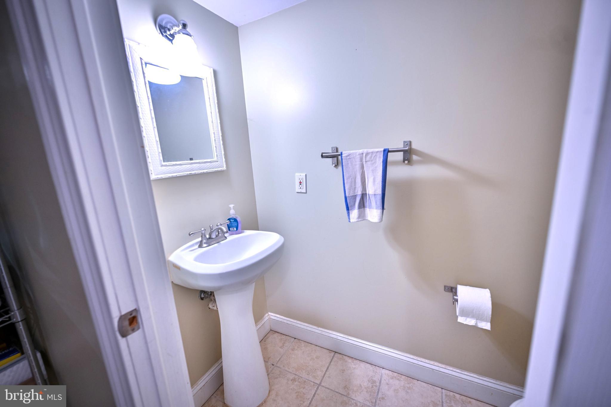 240 Wilson Street Baltimore, MD 21217 - Photo 59 of 63 a bathroom with a sink a mirror and toilet