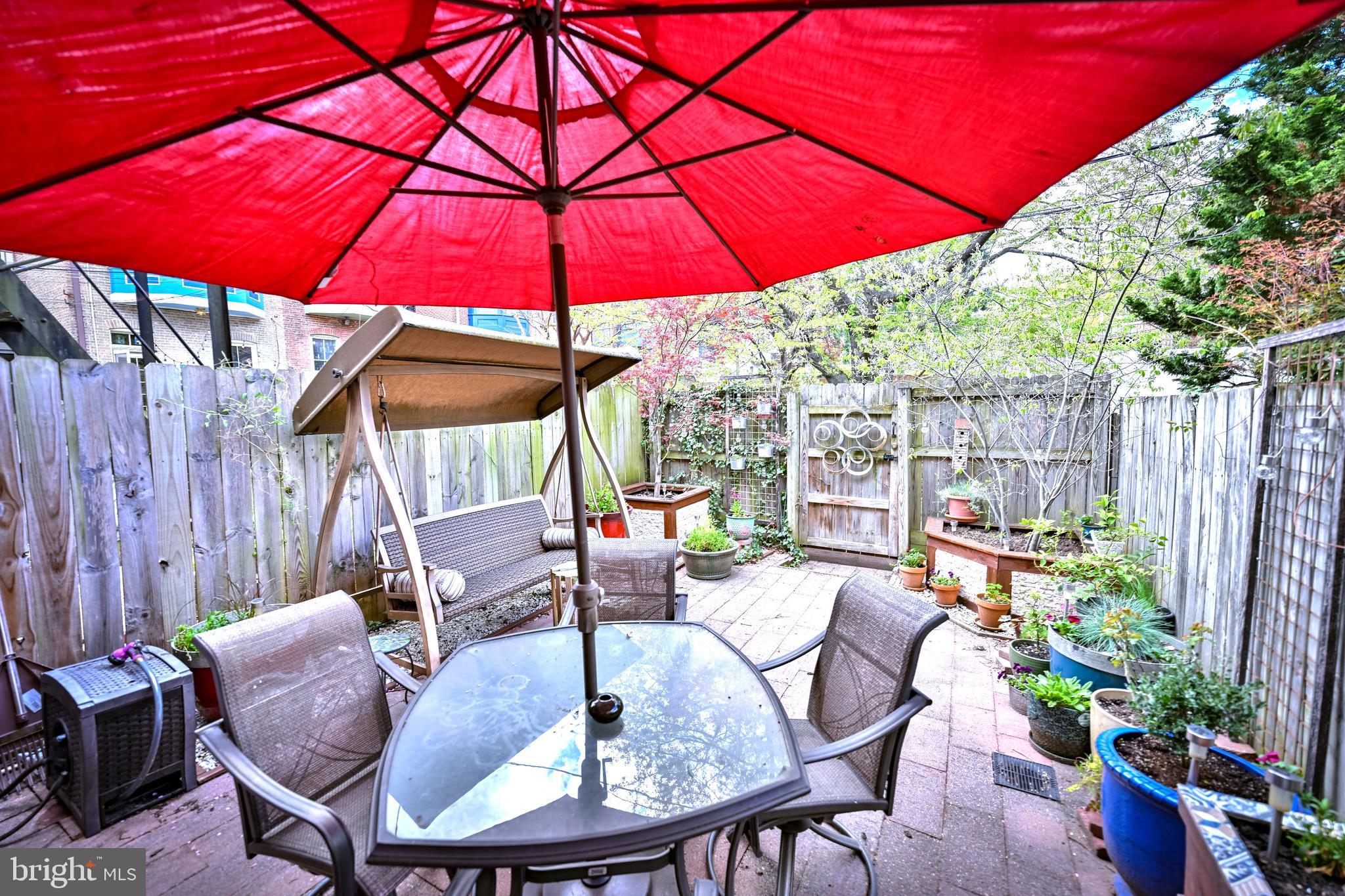 240 Wilson Street Baltimore, MD 21217 - Photo 61 of 63 a patio with tables and chairs with an umbrella