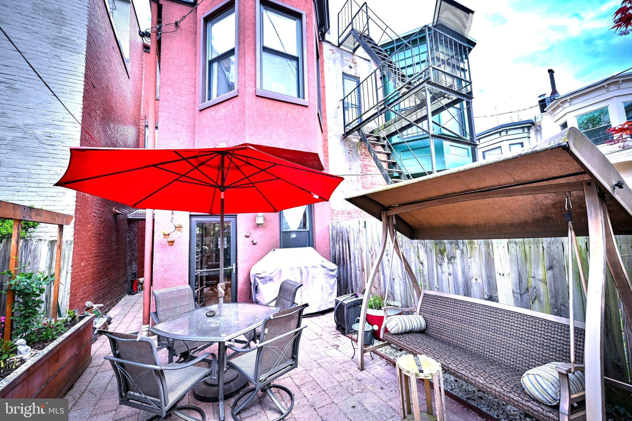 240 Wilson Street Baltimore, MD 21217 - Photo 62 of 63 a view of a patio with a table and chairs under an umbrella