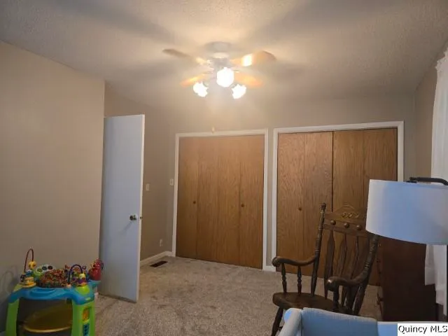 a bedroom with a bed and a fan