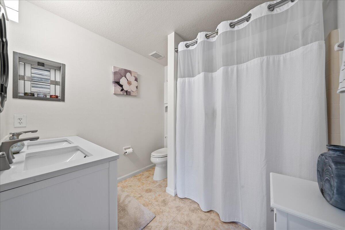 750 Luminary Circle, Unit 103 Melbourne, FL 32901 - Photo 18 of 39 a bathroom with a sink a toilet and a mirror