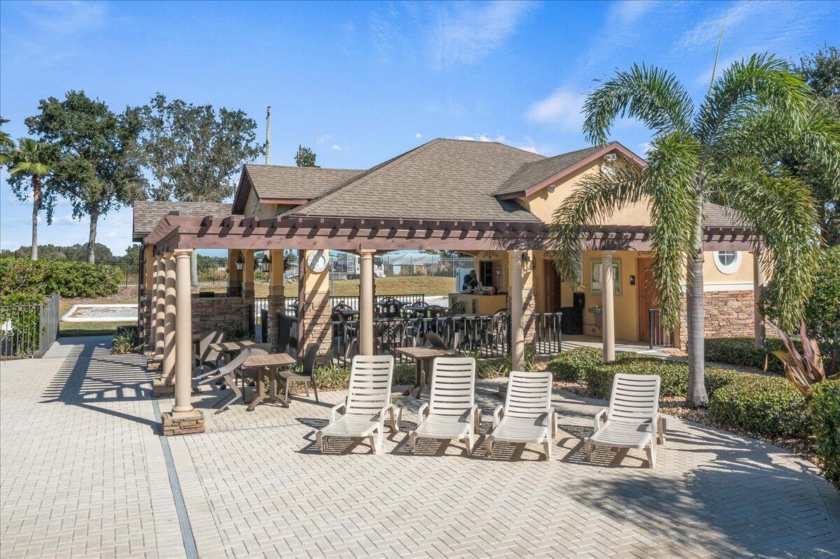 750 Luminary Circle, Unit 103 Melbourne, FL 32901 - Photo 32 of 39 a view of a patio with table and chairs with wooden floor and fence