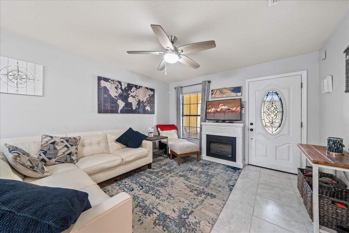 750 Luminary Circle, Unit 103 Melbourne, FL 32901 - Photo 4 of 39 a living room with furniture a fireplace and a flat screen tv