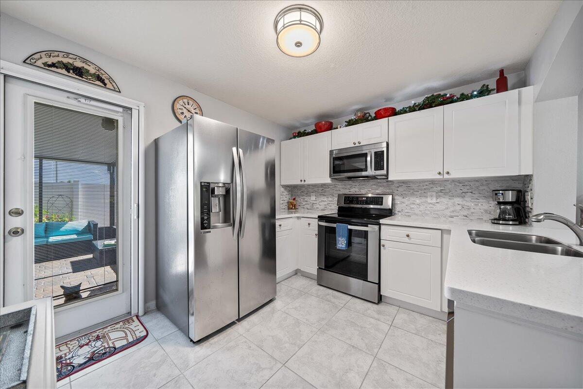 750 Luminary Circle, Unit 103 Melbourne, FL 32901 - Photo 7 of 39 a kitchen with granite countertop a refrigerator stove and microwave
