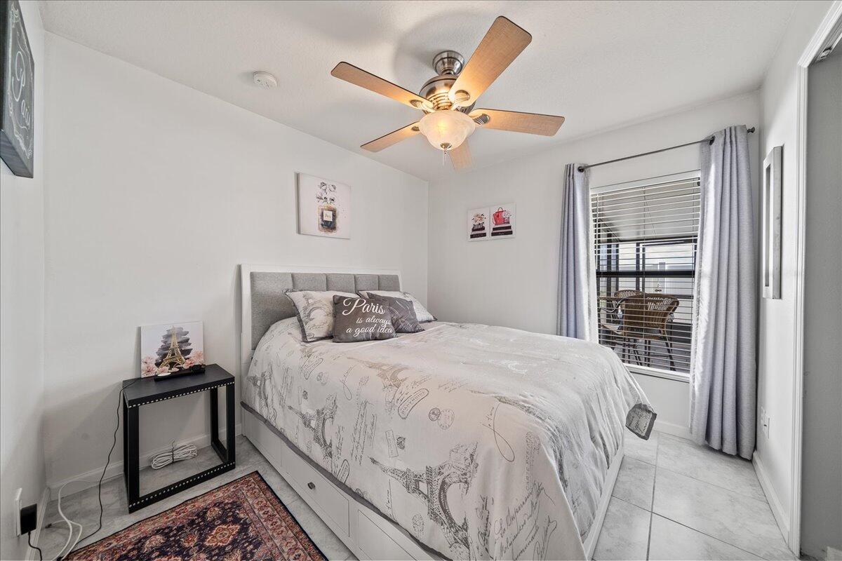 750 Luminary Circle, Unit 103 Melbourne, FL 32901 - Photo 10 of 39 a bedroom with a bed and a chandelier