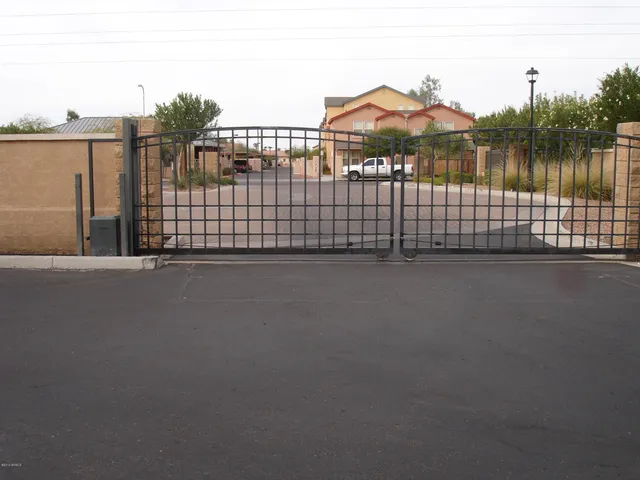 a backyard of a house with large trees and outdoor seating