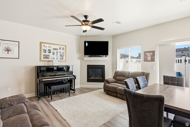 668 East Fiddlers Canyon Road, Unit 6 Cedar City, UT 84721 - Photo 5 of 36 Open-concept living area with wood-finish flooring, a corner fireplace with white mantel, and a ceiling fan with integrated lighting