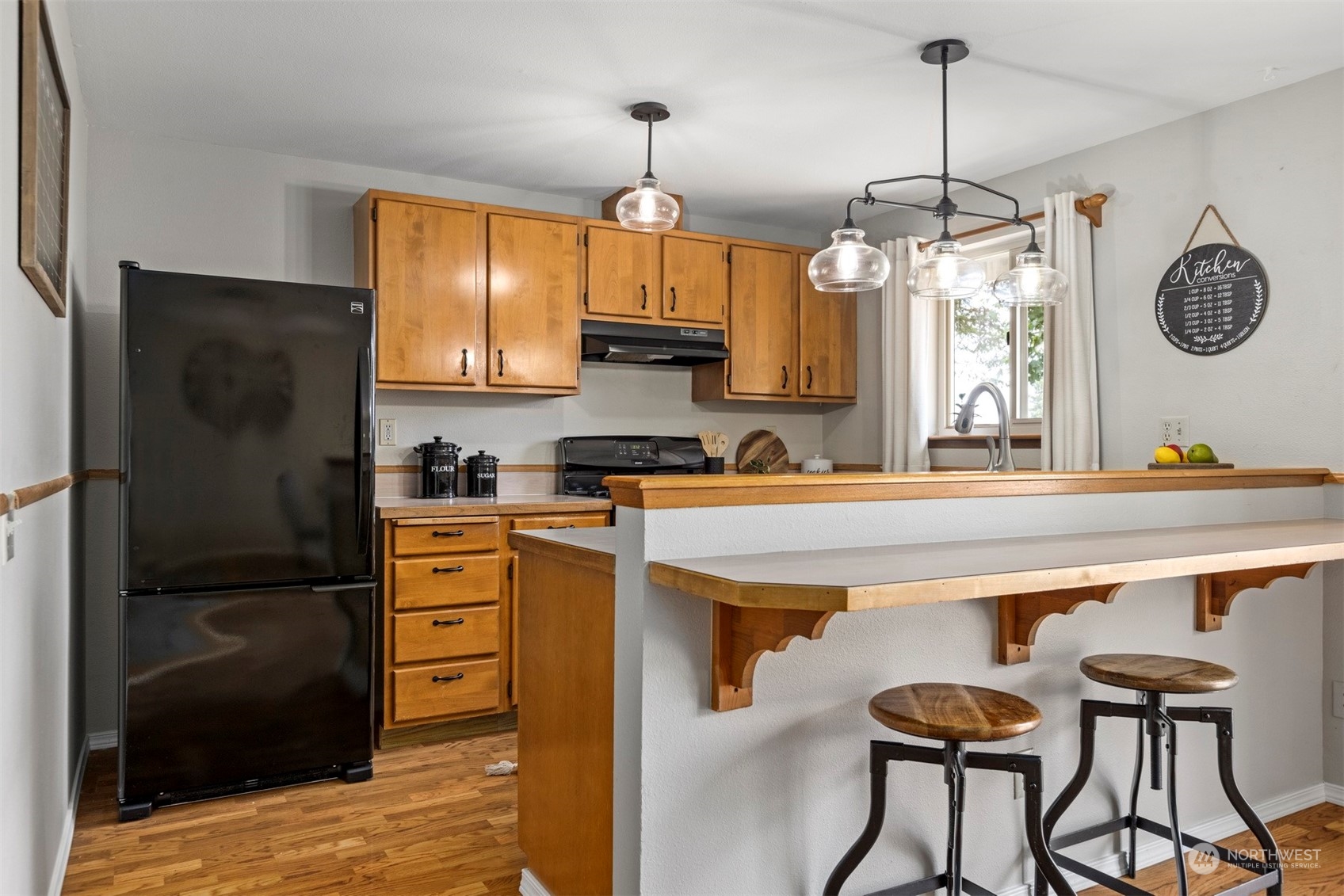 804 Chestnut Street Everson, WA 98247 - Photo 8 of 22 a kitchen with stainless steel appliances granite countertop a refrigerator a sink dishwasher a stove and a dining table with wooden floor