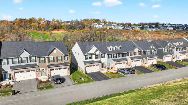 an aerial view of residential houses with outdoor space and ocean view