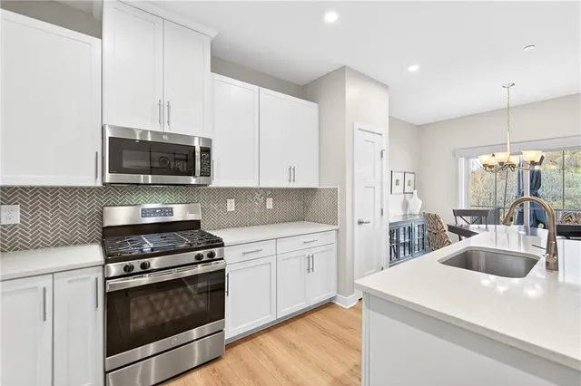 a kitchen with sink a microwave and cabinets