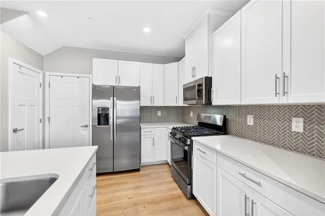 a kitchen with a refrigerator stove and white cabinets