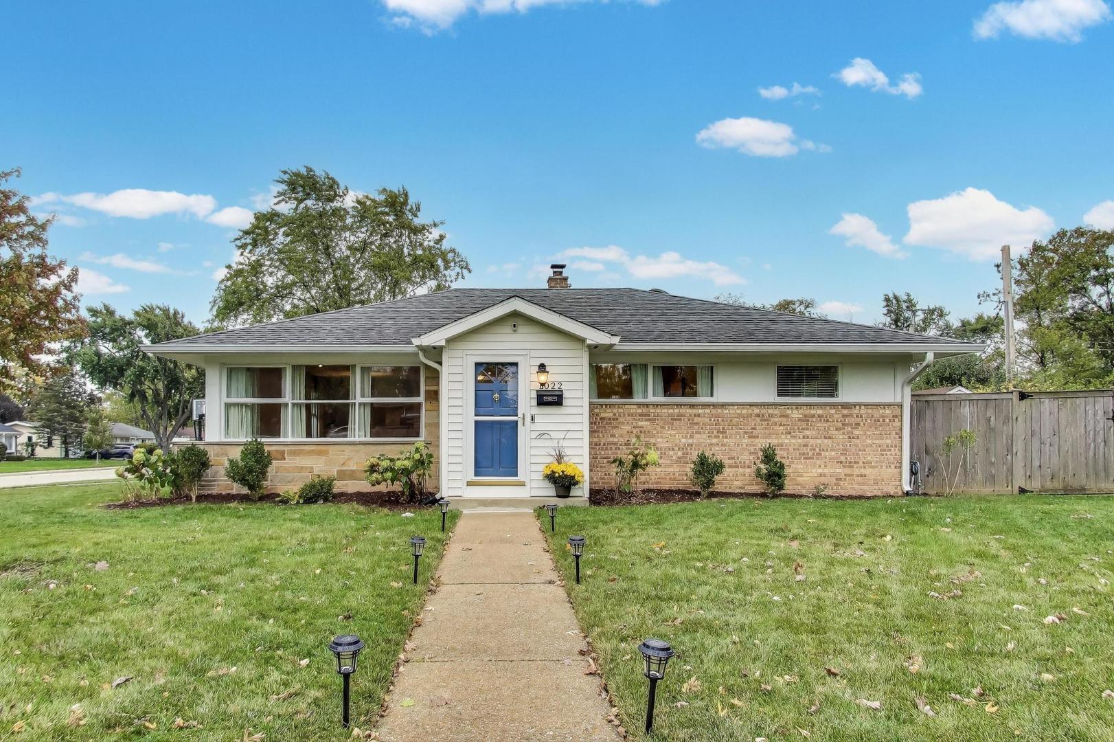 a front view of a house with a yard and trees