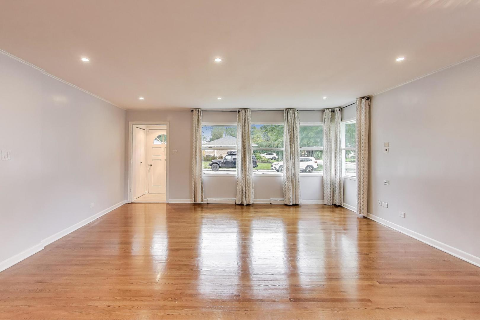 1022 Whitfield Road Northbrook, IL 60062 - Photo 7 of 29 a view of an empty room with a window and wooden floor