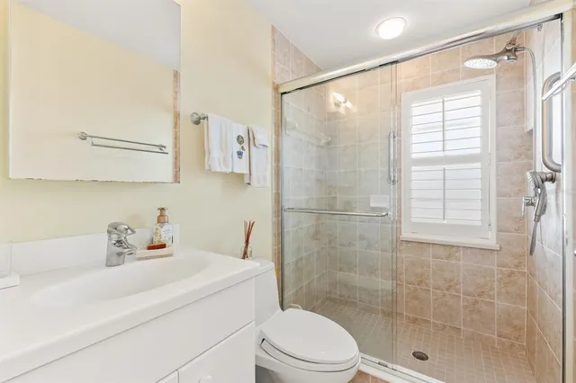 a bathroom with a sink a toilet and shower