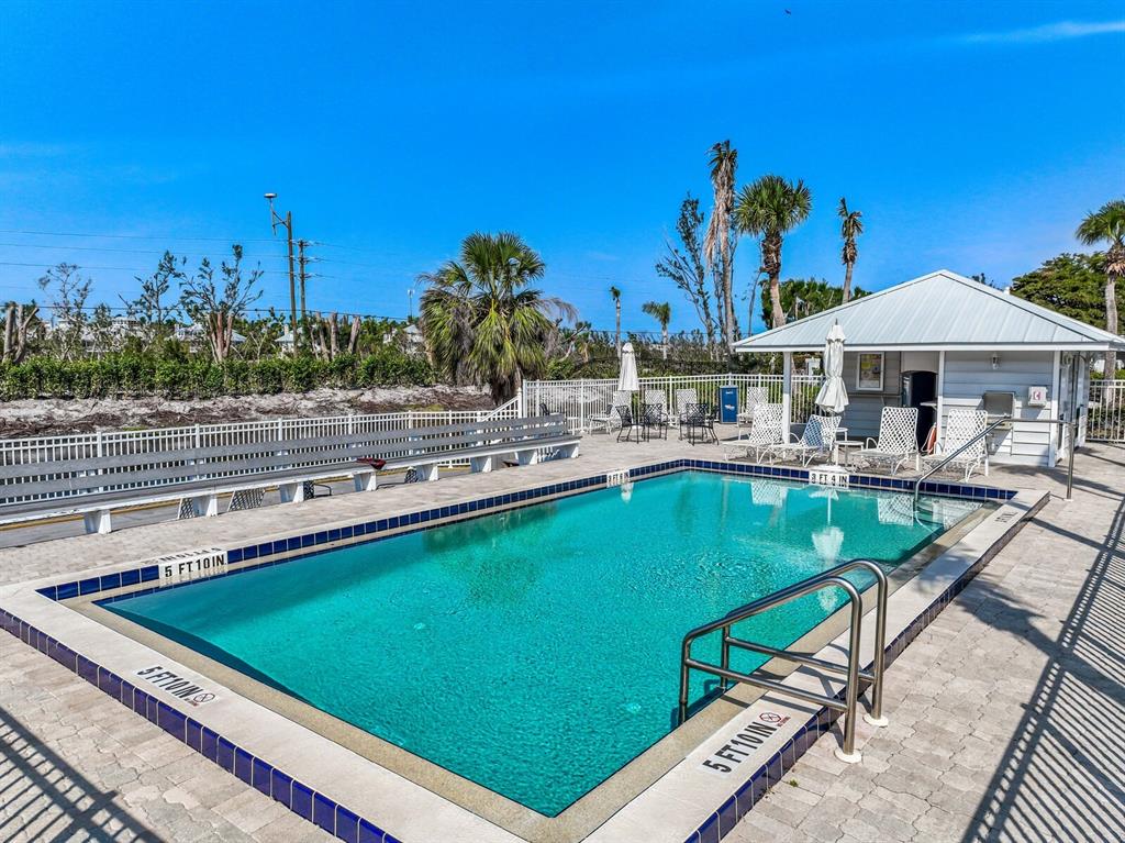 5856 Gasparilla Road, Unit MV26 Boca Grande, FL 33921 - Photo 20 of 38 a view of a swimming pool and lounge chairs