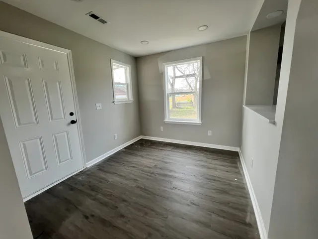 an empty room with wooden floor and chandelier fan