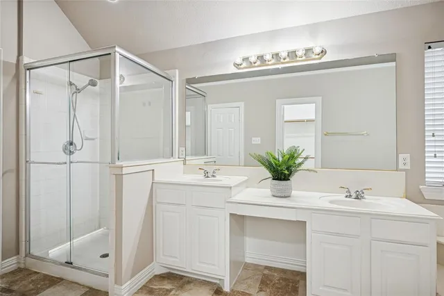 a bathroom with a sink double vanity mirror and a shower