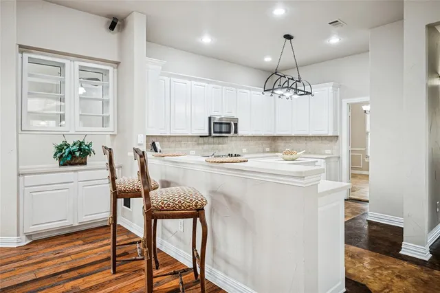a kitchen with kitchen island white cabinets and stainless steel appliances