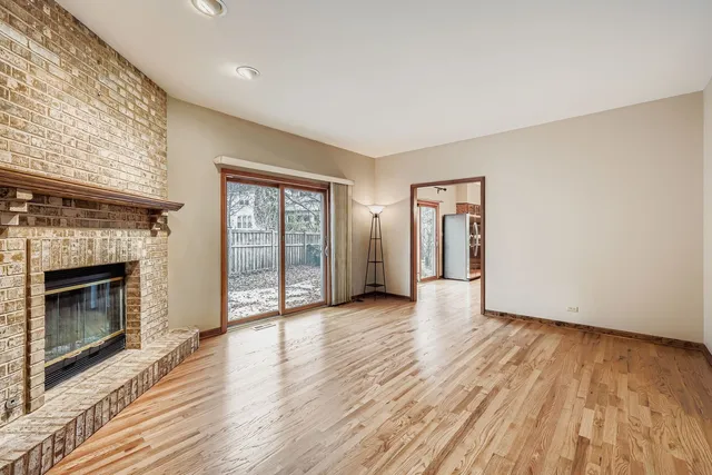 a view of an empty room with window and fire place