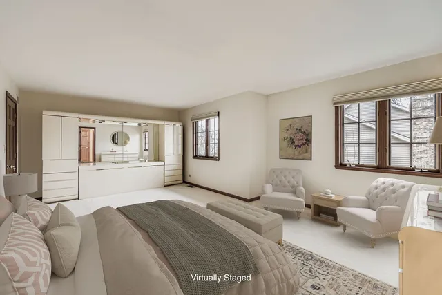 a spacious bedroom with a large bed a couch and two windows