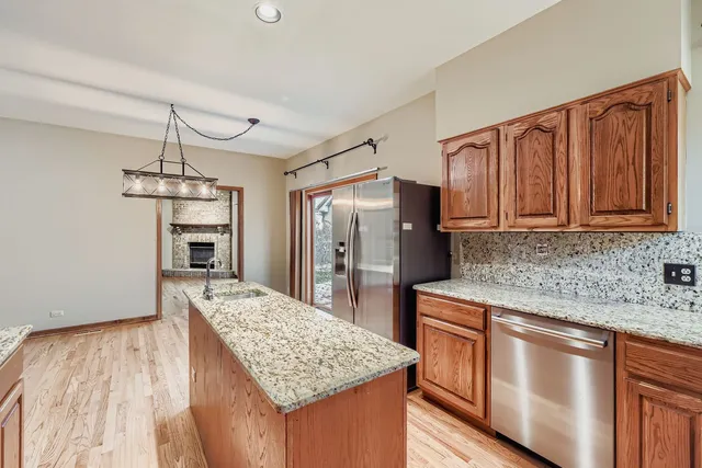 a kitchen with stainless steel appliances granite countertop a sink refrigerator and cabinets