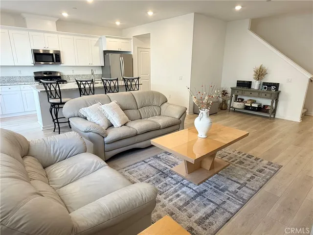 a living room with furniture and a dining table with kitchen view