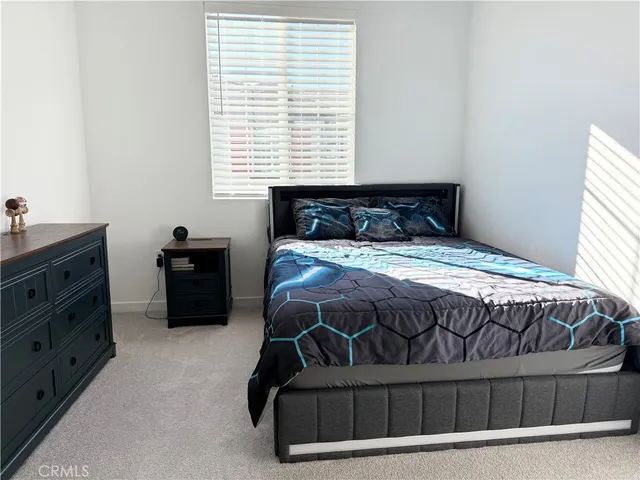 a bedroom with a bed dresser and a window