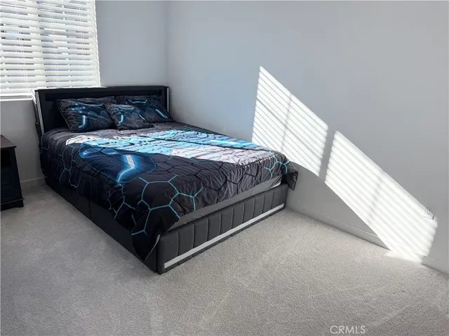 a bed sitting in a bedroom next to a window