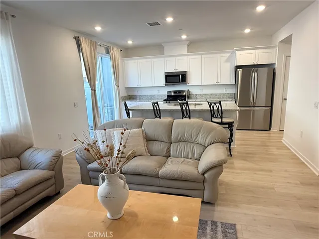a living room with furniture and kitchen view
