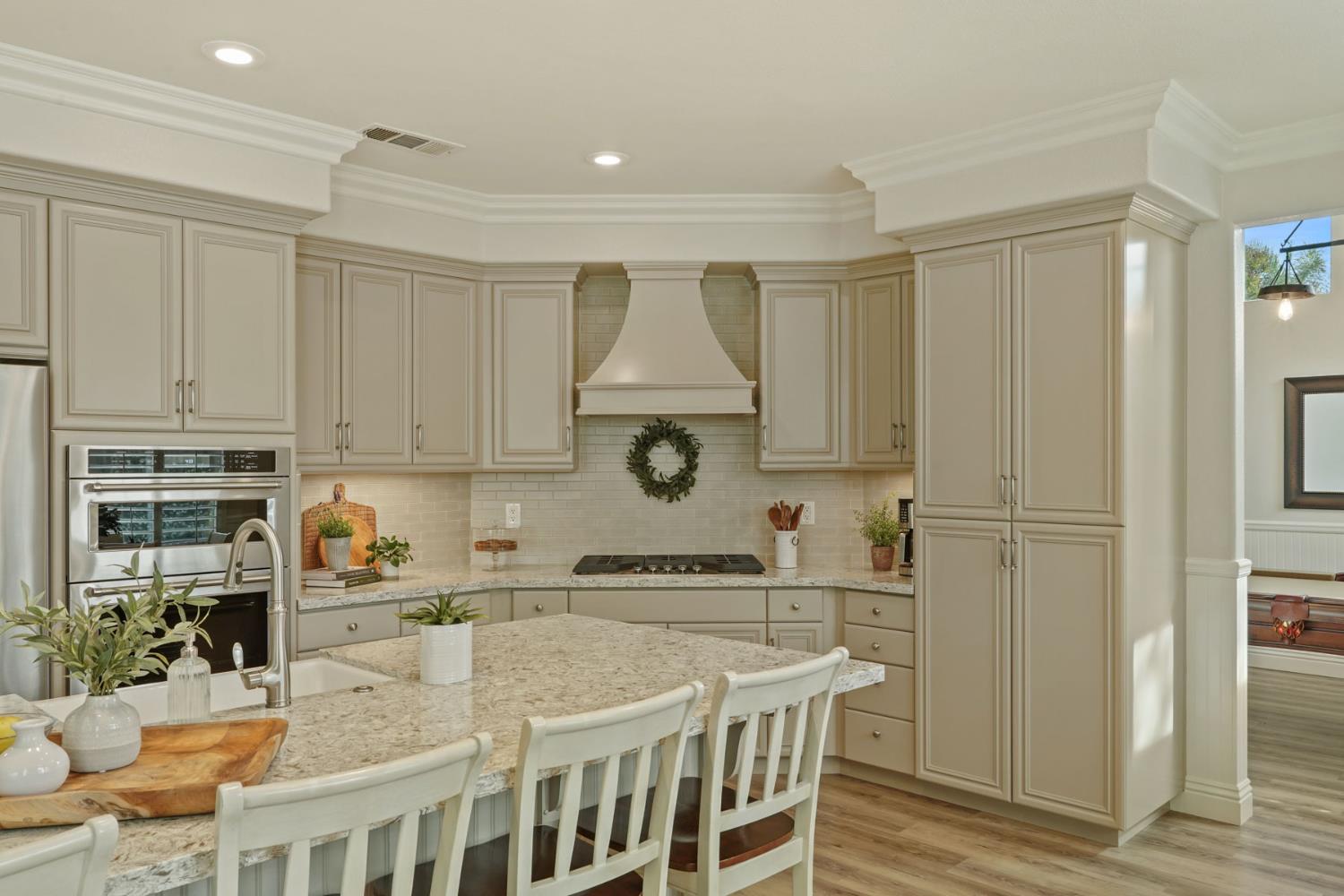 2227 Heavenly Way Lodi, CA 95242 - Photo 22 of 62 a kitchen with stainless steel appliances granite countertop a stove a refrigerator a sink a dining table and chairs with wooden floor