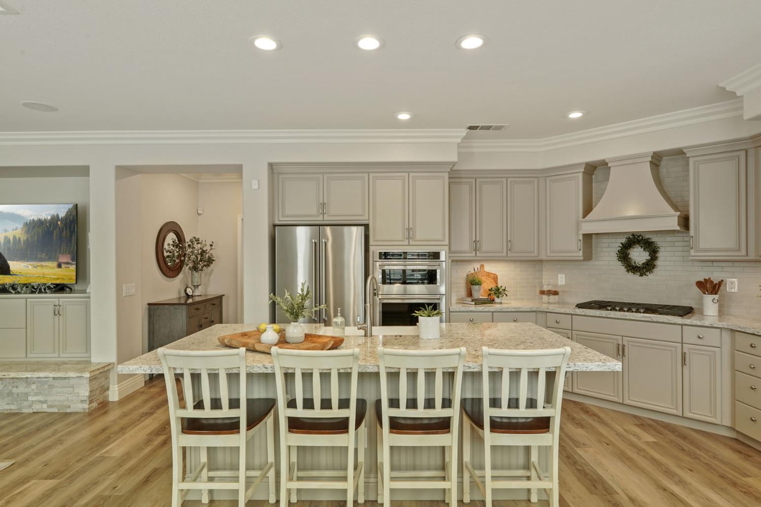 2227 Heavenly Way Lodi, CA 95242 - Photo 23 of 62 a kitchen with stainless steel appliances kitchen island granite countertop a kitchen island and chairs in it