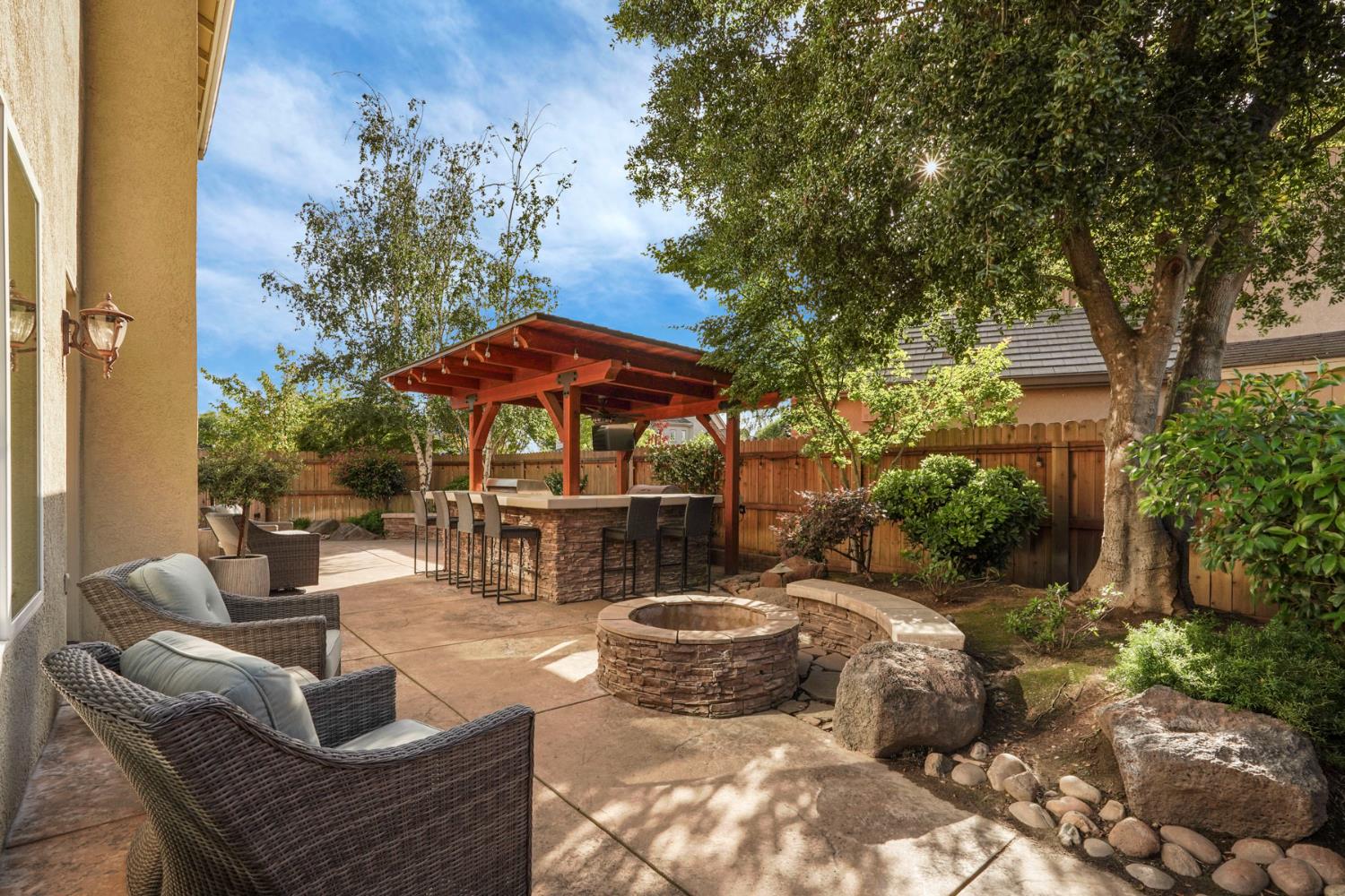 2227 Heavenly Way Lodi, CA 95242 - Photo 50 of 62 a view of a patio with couches and table and chairs under an umbrella with large trees