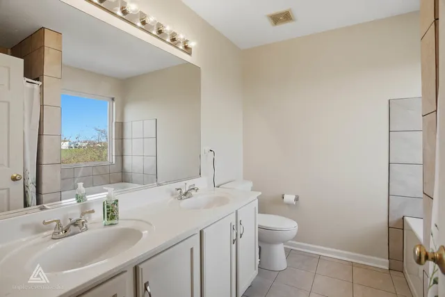 a bathroom with a toilet a sink a mirror and a shower