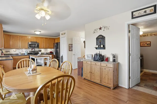 a kitchen with stainless steel appliances granite countertop a dining table and chairs