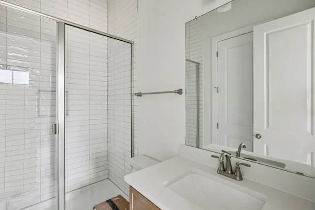 a bathroom with a granite countertop sink a toilet and shower