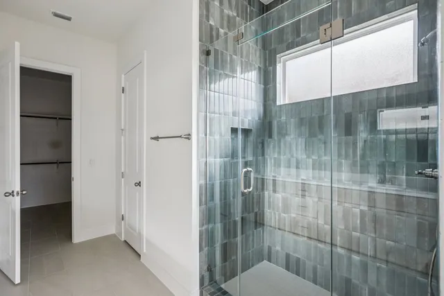 a view of an empty room with wooden floor and white walls