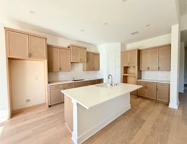 a large white kitchen with a refrigerator a sink and a stove