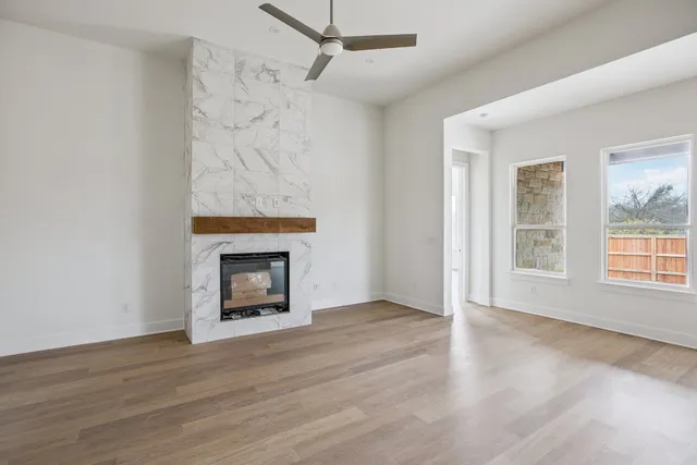 wooden floor fireplace and windows in an empty room