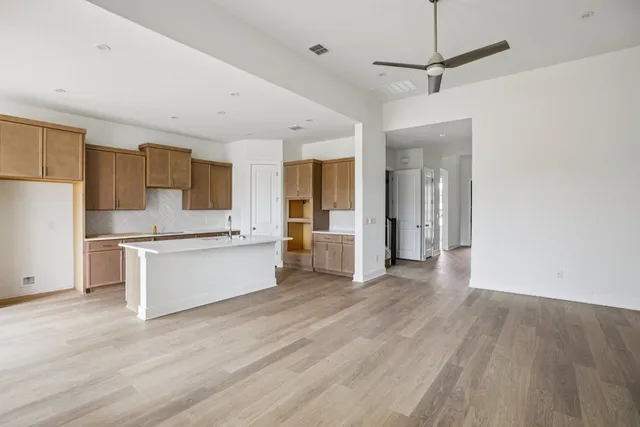 a large white kitchen with a refrigerator a stove top oven a sink and dishwasher