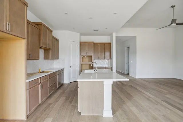 a large kitchen with stainless steel appliances granite countertop a sink stove and refrigerator