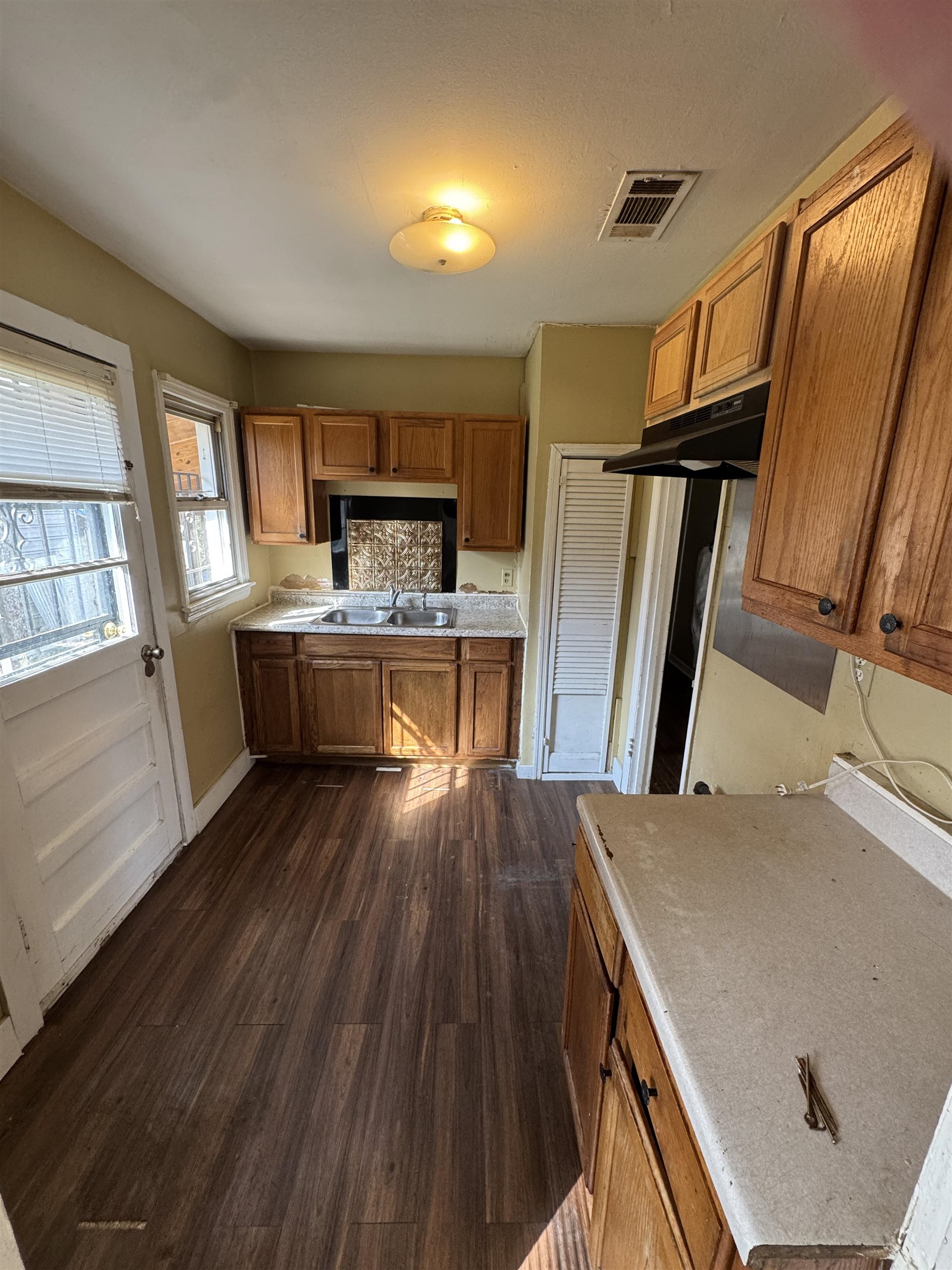 4071 Grey Road Memphis, TN 38108 - Photo 5 of 8 Kitchen with wood finish cabinets, dark wood-type flooring, and light countertops