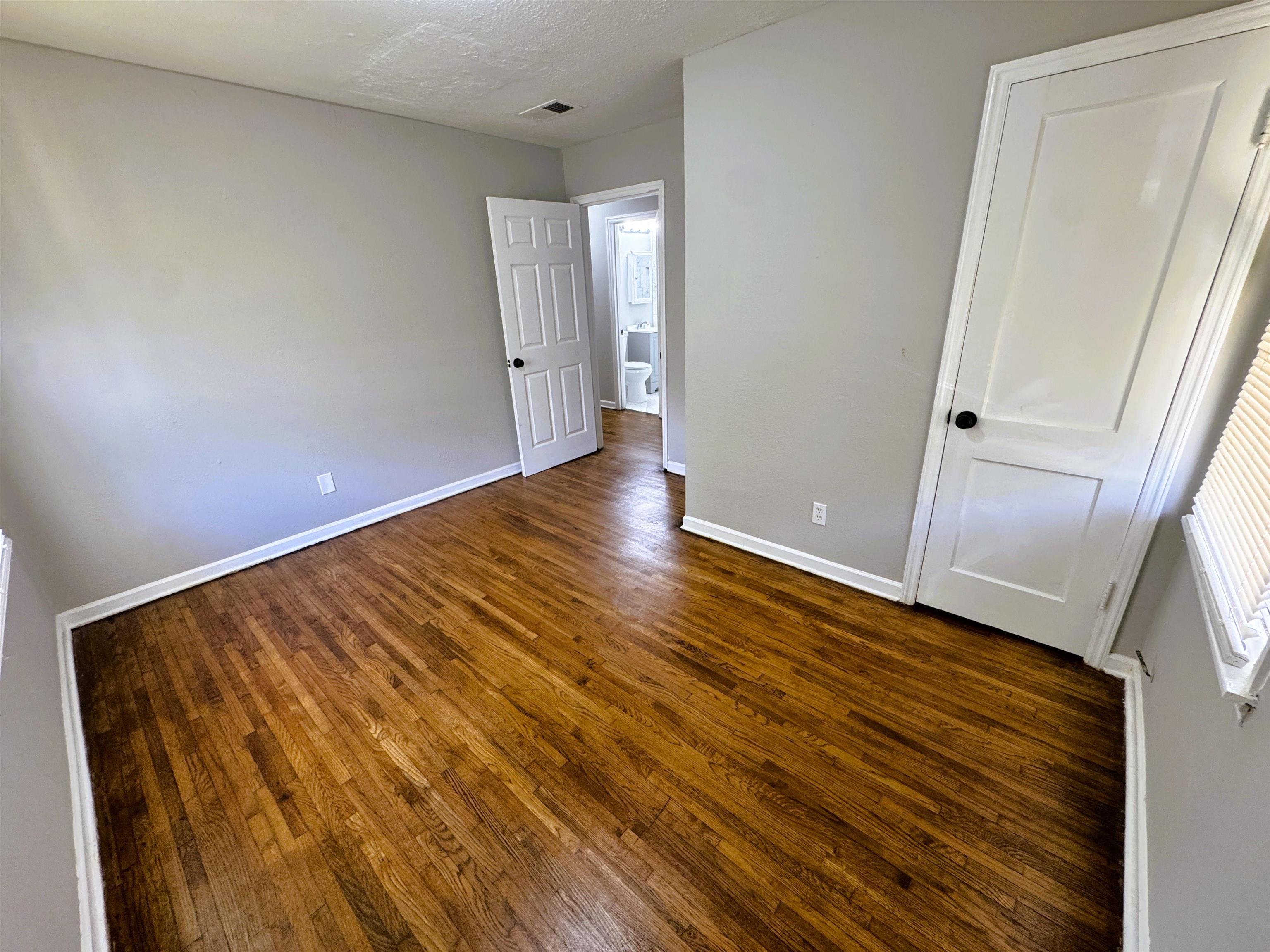 4071 Grey Road Memphis, TN 38108 - Photo 10 of 15 a view of an empty room with wooden floor and a window