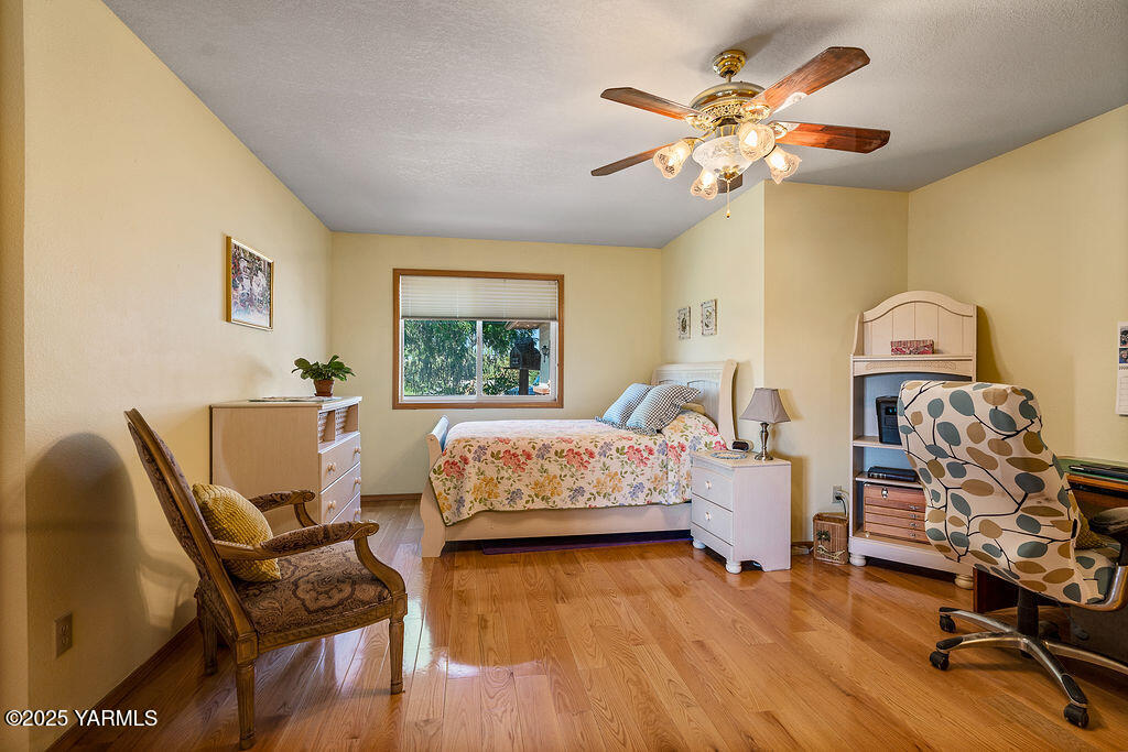 360 Orchardvale Road Zillah, WA 98953 - Photo 16 of 31 a bedroom with a bed and wooden floor