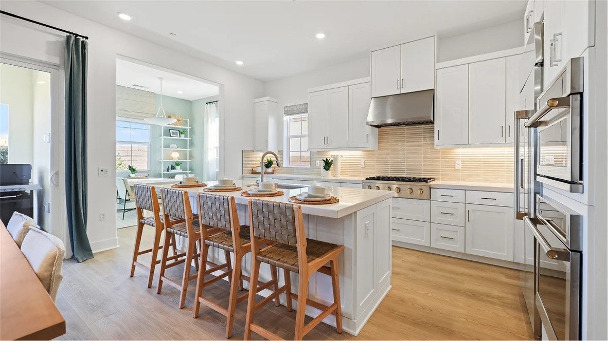 a kitchen with a table chairs refrigerator and microwave