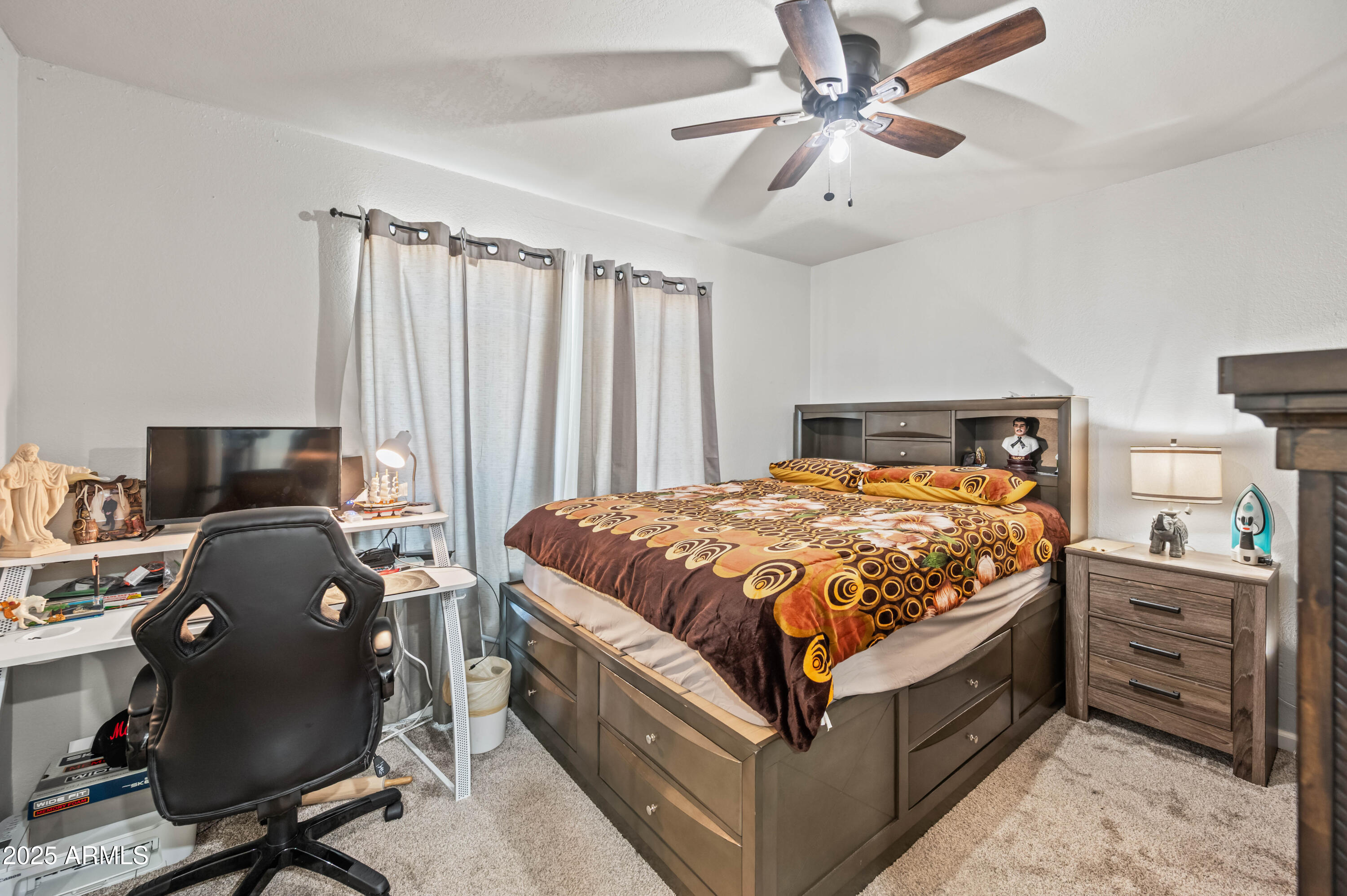 7231 West Flower Street Phoenix, AZ 85033 - Photo 11 of 17 a bedroom with a bed and a chandelier